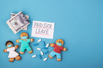 Money, medicine and a gingerbread family in a mask with the inscription paid sick leave