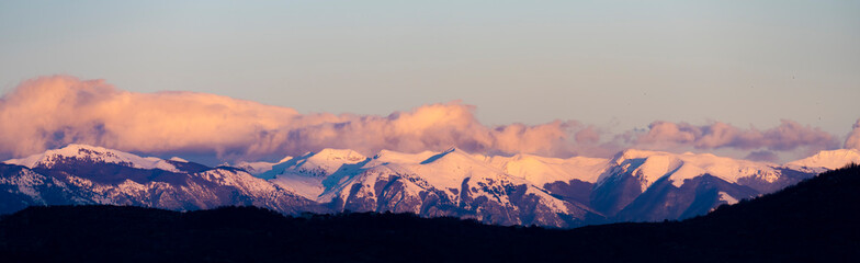 Obraz na płótnie Canvas Stunning view of a snow capped mountain range during a beautiful sunset.