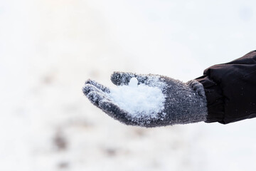 Hands in gray winter gloves. Palm with a glove in the snow. The guy threw snow.