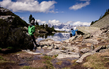 Zwei wandernde Personen blicken über einen wunderschönen Bergsee auf den Österreichischen...
