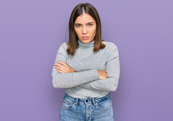 Young beautiful woman wearing casual turtleneck sweater skeptic and nervous, disapproving expression on face with crossed arms. negative person.
