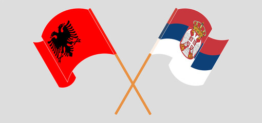 Crossed and waving flags of Albania and Serbia