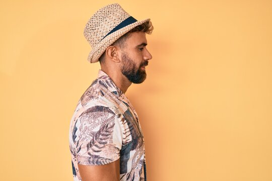 Young hispanic man wearing summer hat looking to side, relax profile pose with natural face with confident smile.