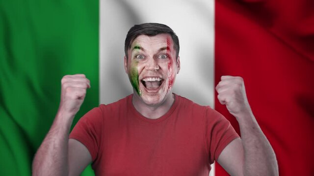 A screaming Italian cheerleader with a face painted in the color of the Italian flag.