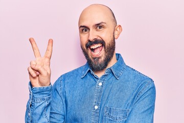 Naklejka premium Young handsome man wearing casual clothes smiling with happy face winking at the camera doing victory sign. number two.