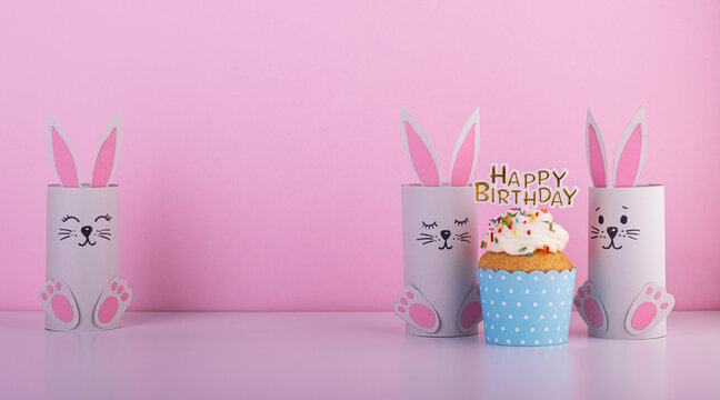 Cute Paper Rabbits From A Roll Of Toilet Paper With The Cake On His Birthday. Background For The Birthday Party