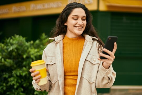 Young middle east woman using smartphone drinking coffee at the city.