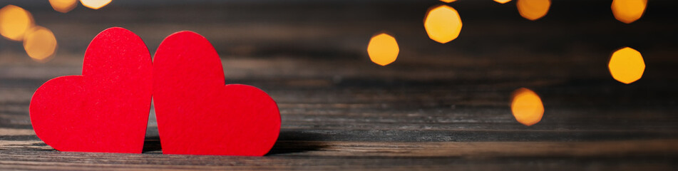 pair of red hearts on lights background, love and valentine concept on a wooden table