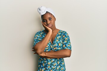 Young african woman wearing hair turban and african style thinking looking tired and bored with depression problems with crossed arms.