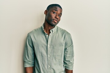 Young african american man wearing casual clothes smiling looking to the side and staring away thinking.