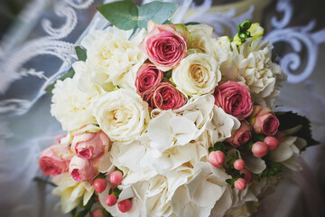 elegant wedding bouquet of white and pink rose flowers. gold wedding rings on the table. preparing for the wedding ceremony