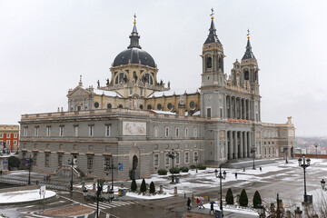 Fototapeta na wymiar Almudena Cathedral in Madrid covered by snow and cold from the storm Filomena. Great snowfall in Madrid. Snow storm.
