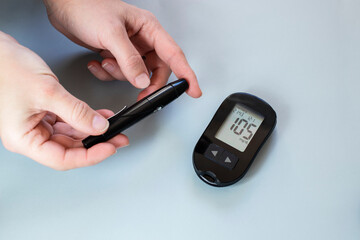 Person using lancelet on finger to check blood sugar level