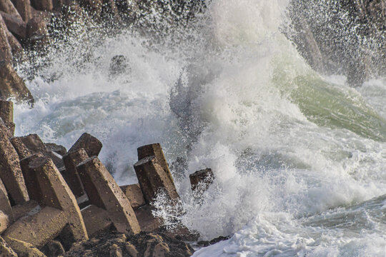 Congelamiento de olas chocando con rompeolas en la costa