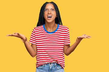 Beautiful hispanic woman wearing casual clothes crazy and mad shouting and yelling with aggressive...