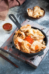 thin pancakes with caviar in a skillet