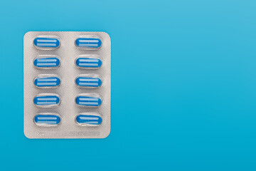 Pharmacy theme, blue pills in capsules, blue background, medicine. Space for text