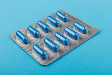 Pharmacy theme, blue pills in capsules, blue background, medicine.