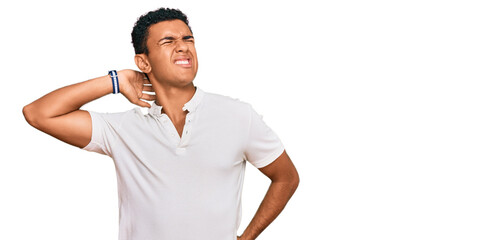 Young arab man wearing casual clothes suffering of neck ache injury, touching neck with hand, muscular pain