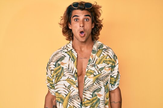 Young hispanic man wearing summer shirt scared and amazed with open mouth for surprise, disbelief face