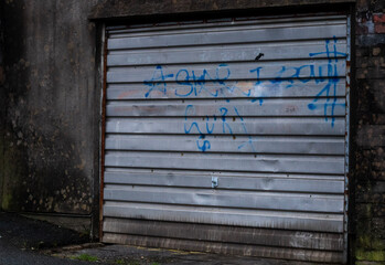 old garage door vandalised by graffiti