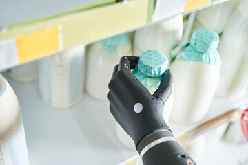 Woman implant hand taking bottle of milk from shelf