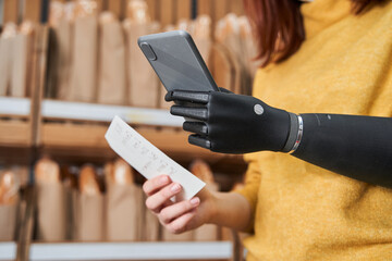 Customer with artificial limb following shopping list