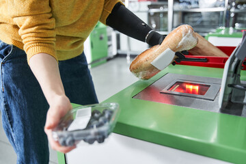 Woman scanning the product at automatic payment machine