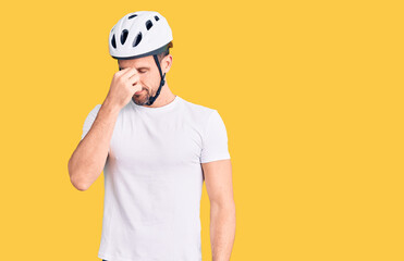 Young handsome man wearing bike helmet tired rubbing nose and eyes feeling fatigue and headache. stress and frustration concept.