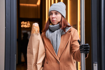 Woman with artificial limb carrying groceries in a paper bag