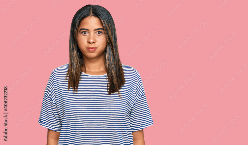 Poster Young latin girl wearing casual clothes puffing cheeks with funny face. mouth inflated with air, crazy expression.