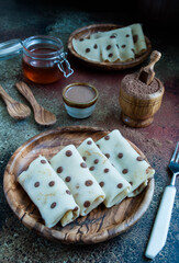 pancakes with cocoa and honey on a wooden plate