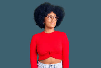 Young african american girl wearing casual clothes and glasses smiling looking to the side and staring away thinking.