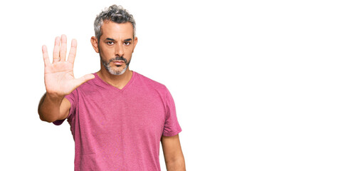 Middle age grey-haired man wearing casual clothes doing stop sing with palm of the hand. warning expression with negative and serious gesture on the face.