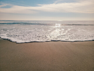 A minimal beach shore. Soft wave of the Ocean on the sandy beach. Rockaway Beach, New York. 