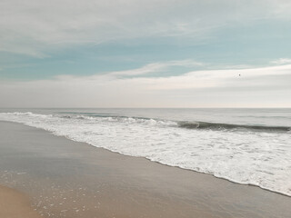 A minimal beach shore. Soft wave of the Ocean on the sandy beach. Rockaway Beach, New York. 