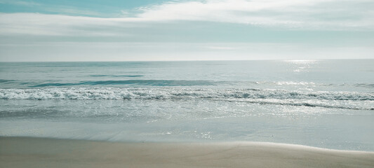Fototapeta na wymiar A minimal beach shore. Soft wave of the Ocean on the sandy beach. Rockaway Beach, New York. 