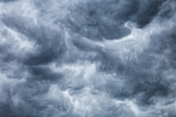 Dark cloudy sky before thunderstorm background. Storm heaven clouds in sky. Wide gloomy backdrop approaching storm.