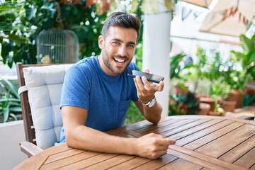 Young hispanic man having conversation talking on the smartphone at the terrace.