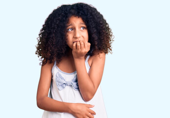 African american child with curly hair wearing casual clothes looking stressed and nervous with hands on mouth biting nails. anxiety problem.