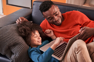 Father and son relaxing and having fun with laptop
