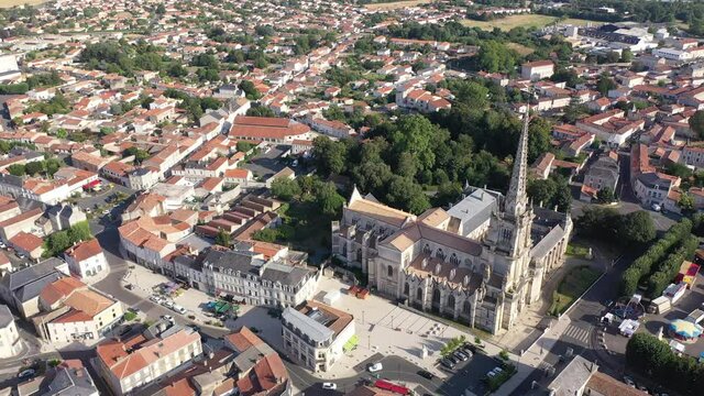 View from drone of houses and ancient Roman Catholic Cathedral of Lucon town at summer day, France