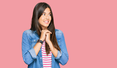 Young brunette woman wearing casual clothes laughing nervous and excited with hands on chin looking...