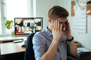 Man Fatigue during home video conference meeting call. Post-work exhaustion from constant...