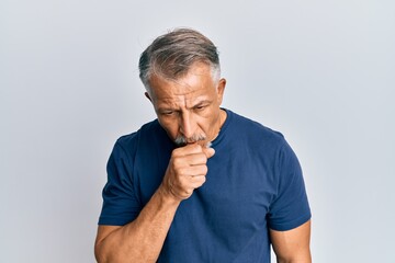 Middle age grey-haired man wearing casual clothes feeling unwell and coughing as symptom for cold or bronchitis. health care concept.