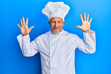 Middle age grey-haired man wearing professional cook uniform and hat showing and pointing up with fingers number ten while smiling confident and happy.