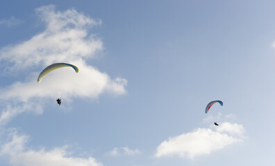 A beautiful view of a paraglide flying gliding on a clear blue sky at the golden hour with a nice wind windy breeze on a sunny day 