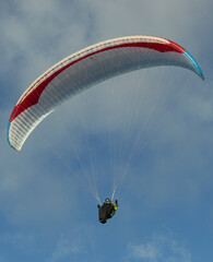 A beautiful view of a paraglide flying gliding on a clear blue sky at the golden hour with a nice wind windy breeze on a sunny day 