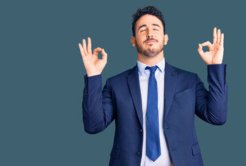 Young hispanic man wearing business clothes relax and smiling with eyes closed doing meditation gesture with fingers. yoga concept.