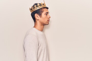 Young african amercian man wearing prince crown looking to side, relax profile pose with natural...
